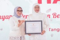 Khofifah Indar Parawansa (kanan) saat menerima penghargaan dari Kementerian Pemberdayaan Perempuan dan Perlindungan Anak (Kementerian PPA) pada puncak acara Peringatan Hari Ibu ke-64 di Tangerang, Minggu (22/12/2024). 